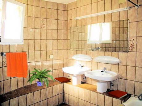 La mme salle de bain, avec quelques lments de dcor: linge de couleur vive, pot avec une plante verte