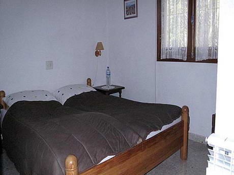 Chambre  coucher pratiquement mono-chromatique, dj pas bien grande, mais l'absence de couleur n'arrange rien