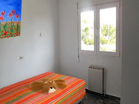 La mme chambre  coucher avec un couvre-lit de couleur vive, et une sympathique peluche sur le lit