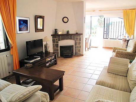 Le mme sjour avec chemine, avec des rideaux aux couleurs vives, et un tableau, bleu vif galement