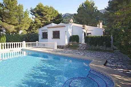 Terrasse d'une piscine, avec villa derrire, partiellement dans l'ombre, impression frache