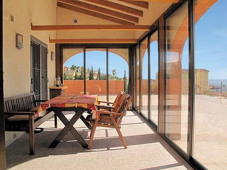 La mme terrasse couverte vitre, avec ciel bleu, nettement plus gaie