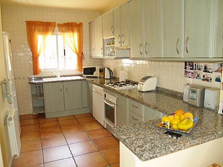 Cuisine impeccable, avec un plateau de fruits exotiques en avant-plan et rien d'autre sur le plan de travail