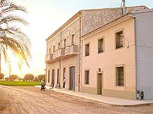 Sonnenuntergang beer einem alten Landhaus aus rosarotem Backstein in der Gegend Elche, Alicante Provinz in Spanien