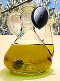 Flacon d'huile d'olive surmonté d'une olive pendant à une branche d'olivier